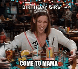 A Woman Wearing A Tiara Is Sitting At A Table With Drinks And Says `` Birthday Girl Come To Mama '' . GIF