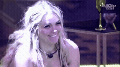 A Woman Wearing A Tiara Is Smiling In Front Of A Big Brother Brasil Logo GIF