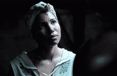A Woman Wearing A Turban And A White Shirt Looks Up At Something GIF