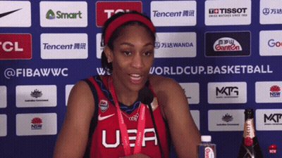 A Woman Wearing A U.s.a. Jersey Stands In Front Of A Wall Of Sponsors GIF
