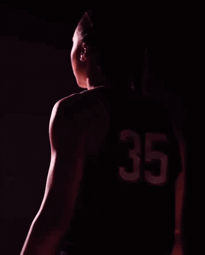 A Woman Wearing A Uconn Jersey With The Number 35 GIF