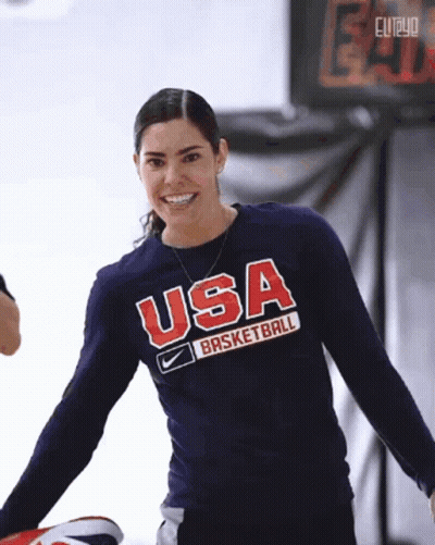 A Woman Wearing A Usa Basketball Shirt Smiles For The Camera GIF