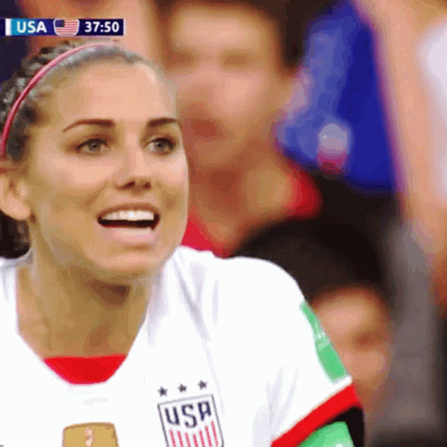 A Woman Wearing A Usa Jersey Smiles While Watching A Soccer Game GIF