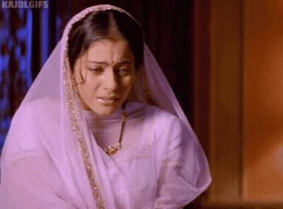 A Woman Wearing A Veil And A Necklace Is Crying And Looking Down . GIF