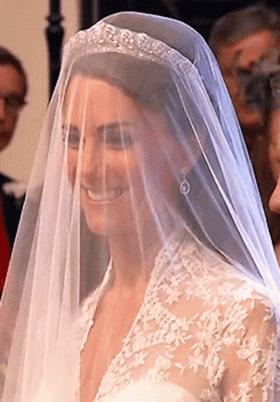A Woman Wearing A Veil And A Tiara Smiles GIF