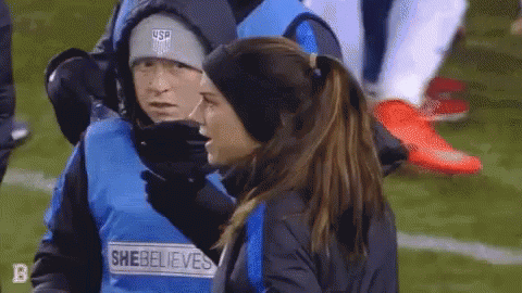 A Woman Wearing A Vest That Says She Believes On It GIF