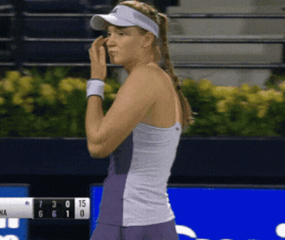 A Woman Wearing A Visor Is Standing In Front Of A Scoreboard That Shows The Score Of 7 To 15 GIF
