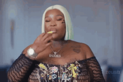 A Woman Wearing A Watch And A Necklace With The Word Baddies On It . GIF