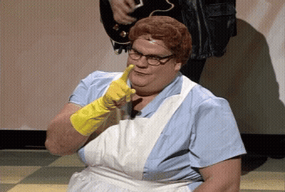 A Woman Wearing A White Apron And Yellow Gloves Is Pointing At The Camera GIF