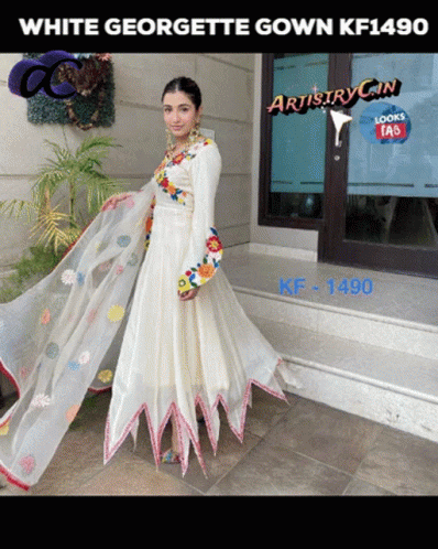 A Woman Wearing A White Georgette Gown Kf1490 Stands In Front Of A Building GIF