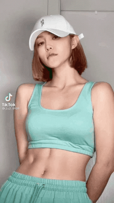 A Woman Wearing A White Hat And A Crop Top Has Tiktok Written On The Bottom GIF