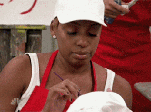 A Woman Wearing A White Hat Is Painting A White Object GIF