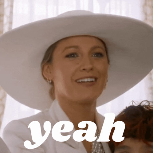 A Woman Wearing A White Hat Is Smiling With The Word Yeah Above Her GIF