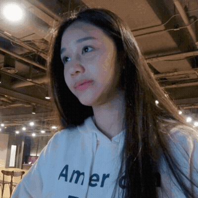A Woman Wearing A White Hoodie That Says " America " GIF