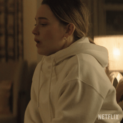 A Woman Wearing A White Hoodie With The Word Netflix On The Bottom GIF