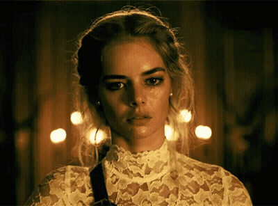 A Woman Wearing A White Lace Top Has A Tear Running Down Her Face GIF