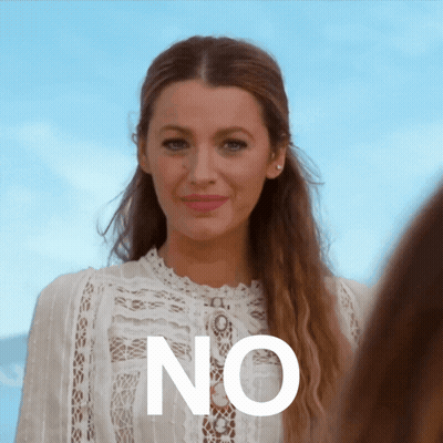 A Woman Wearing A White Lace Top Stands In Front Of A Sign That Says " No " GIF