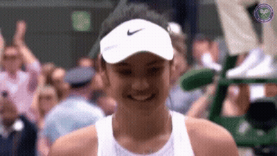 A Woman Wearing A White Nike Hat Smiles In Front Of A Crowd GIF