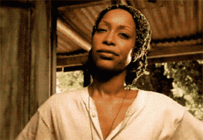 A Woman Wearing A White Shirt And A Scarf Around Her Head GIF