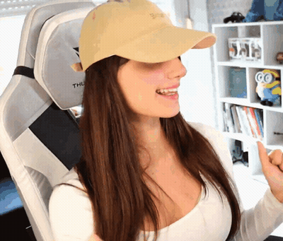 A Woman Wearing A White Shirt And A Yellow Hat Is Sitting In A Chair That Says Thule GIF