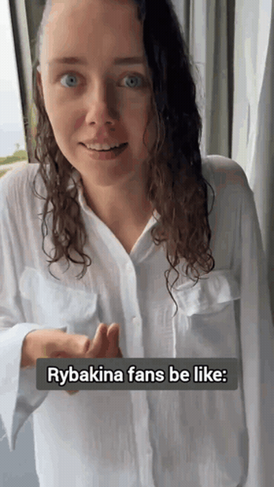 A Woman Wearing A White Shirt Is Standing In Front Of A Window With The Caption Rybakina Fans Be Like GIF