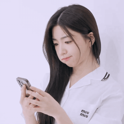 A Woman Wearing A White Shirt With Miu Written On The Pocket GIF