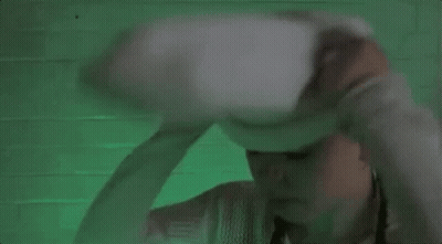 A Woman Wearing A White Sweater And A White Hat With A Face On It . GIF