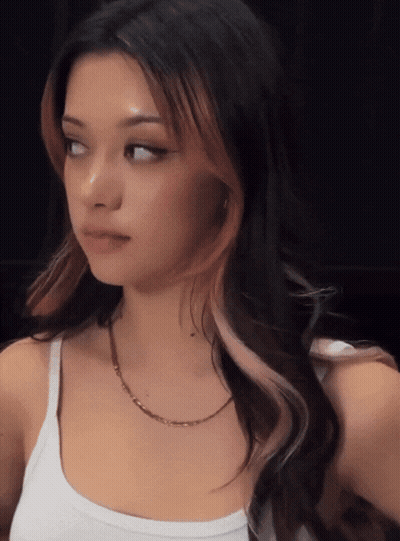 A Woman Wearing A White Tank Top And A Gold Chain GIF