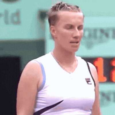 A Woman Wearing A White Tank Top With A Fila Logo On The Front GIF