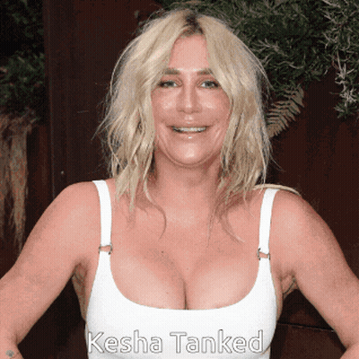 a woman wearing a white tank top with the name kesha tanked on the bottom