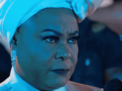 A Woman Wearing A White Turban And Earrings Looks Serious GIF