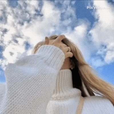 A Woman Wearing A White Turtleneck Sweater Covering Her Face With Her Hand GIF