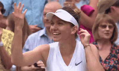 A Woman Wearing A White Visor And A White Tank Top Is Smiling And Waving At The Crowd . GIF