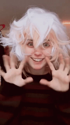 A Woman Wearing A White Wig Is Smiling And Making A Funny Face GIF