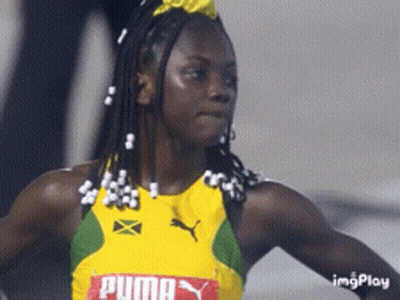 A Woman Wearing A Yellow And Green Puma Jersey GIF
