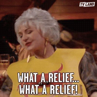A Woman Wearing A Yellow Bib That Says What A Relief What A Relief GIF
