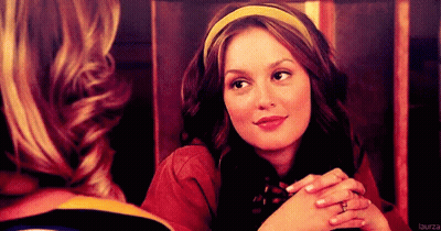 A Woman Wearing A Yellow Headband Is Smiling And Looking At Another Woman GIF