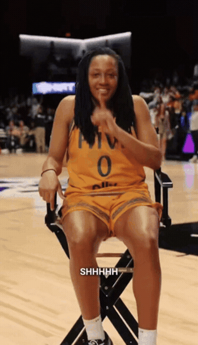 A Woman Wearing A Yellow Jersey With The Number 0 On It Sits In A Chair GIF