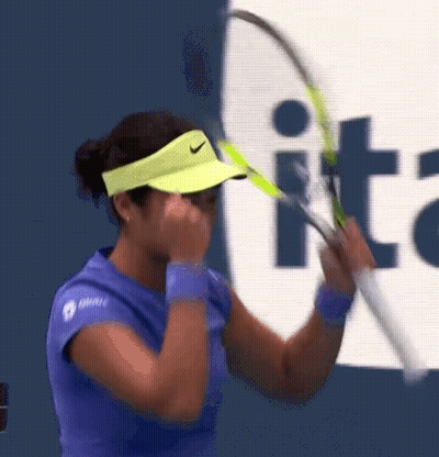 A Woman Wearing A Yellow Nike Visor Is Holding A Tennis Racket GIF