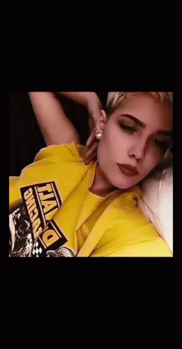 A Woman Wearing A Yellow Shirt That Says Dewalt Is Blowing Purple Smoke Out Of Her Mouth GIF
