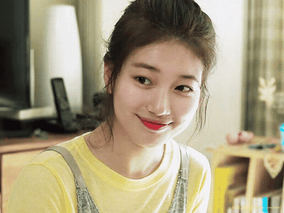 A Woman Wearing A Yellow T-Shirt And Overalls Smiles For The Camera GIF