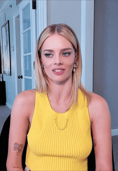 a woman wearing a yellow tank top has a tattoo on her arm