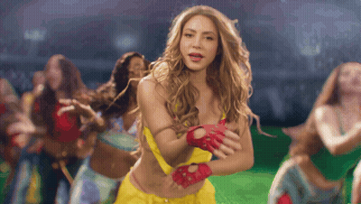 A Woman Wearing A Yellow Top And Red Gloves Is Dancing GIF