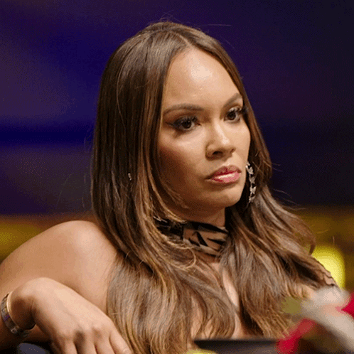 A Woman Wearing A Zebra Print Scarf And Earrings Looks To The Side GIF