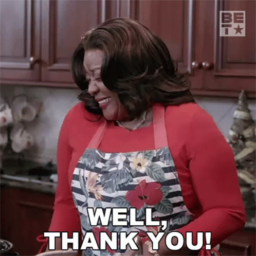 A Woman Wearing An Apron Is Saying Well Thank You GIF