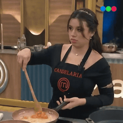 A Woman Wearing An Apron That Says Candelaria Is Stirring Food In A Frying Pan GIF