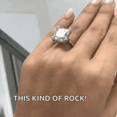 A Woman Wearing An Emerald Cut Diamond Ring On Her Left Hand GIF