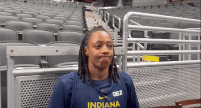 A Woman Wearing An Indiana Shirt Stands In An Empty Auditorium GIF