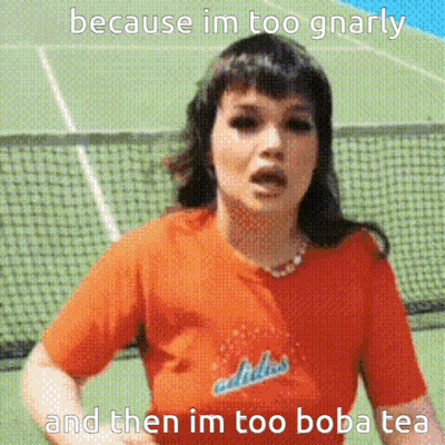 A Woman Wearing An Orange Adidas Shirt Is Standing In Front Of A Tennis Court GIF