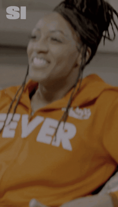 A Woman Wearing An Orange Hoodie With The Word Fever On It GIF
